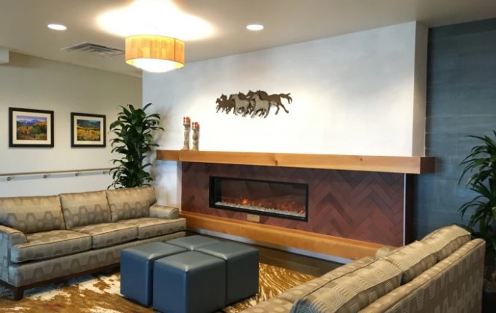 A modern living room with comfortable seating, a sleek fireplace, and decorative artwork.