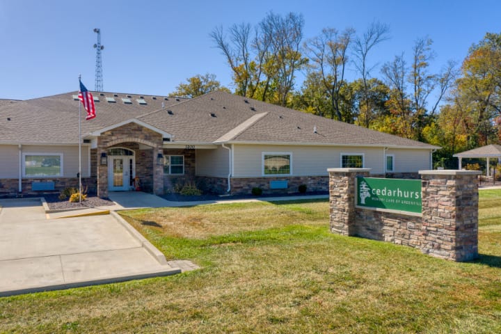 A single-story office building with a sign on the lawn and the American flag displayed outside.