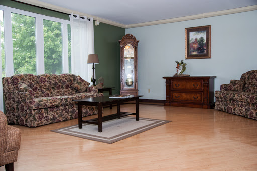 A cozy and well-furnished living room featuring a floral sofa, wooden coffee table, and elegant decor.