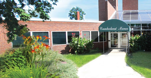 A well-maintained brick building with a welcoming entrance and vibrant landscaping.