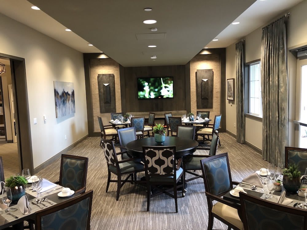 A well-decorated dining room with multiple tables and chairs arranged for dining.