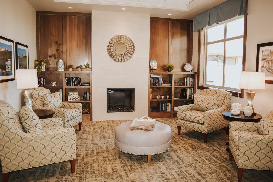 A cozy living room with a fireplace, armchairs, and warm wooden accents.