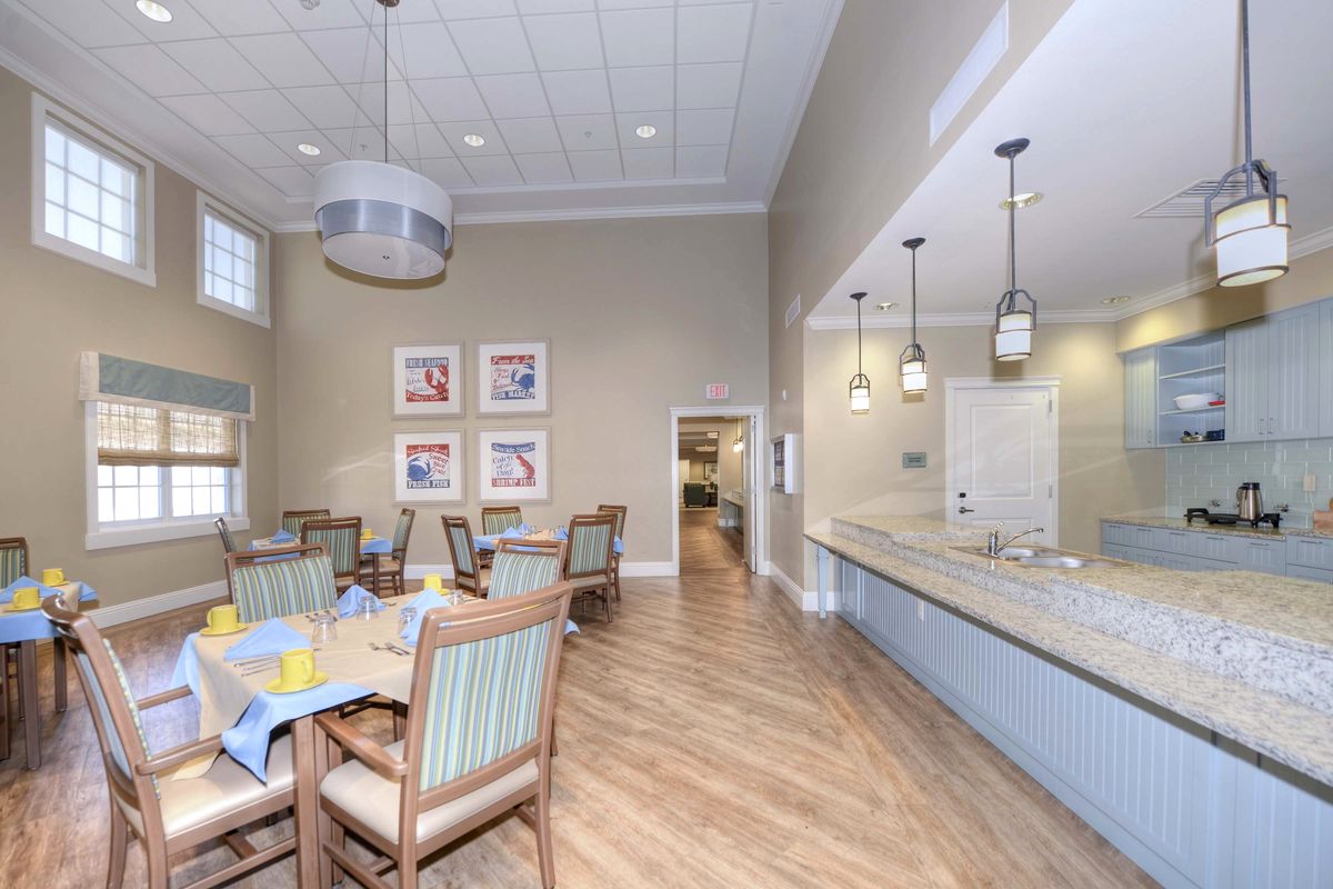 A modern dining room with wooden flooring, stylish furniture, and elegant lighting.