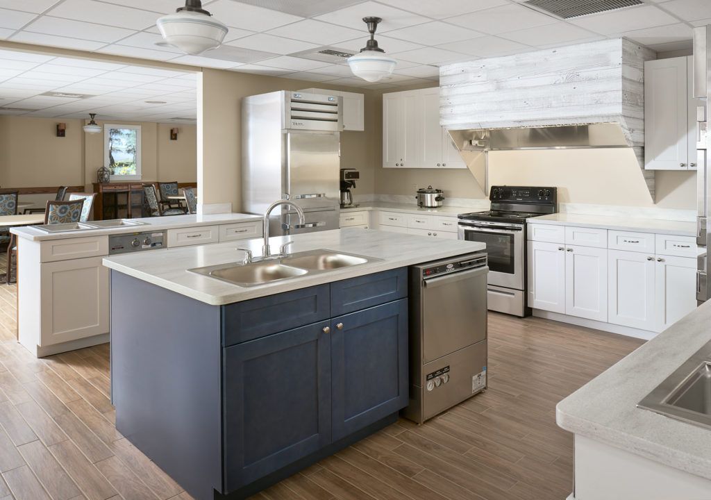 A modern kitchen featuring a central island with a double sink, stainless steel appliances, and sleek countertops.