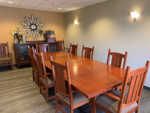 A spacious dining area featuring a large wooden table surrounded by matching chairs, perfect for meetings or gatherings.