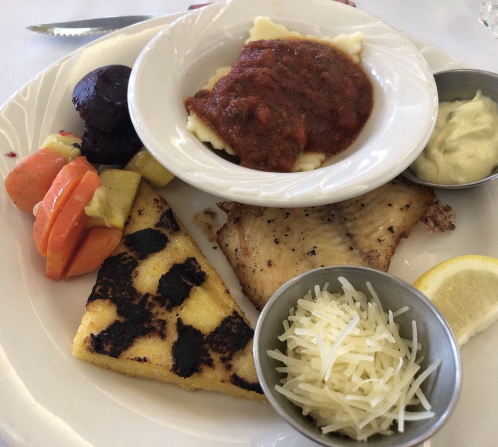 A diverse plate featuring ravioli with tomato sauce, grilled fish, vegetables, frittata, and grated cheese.