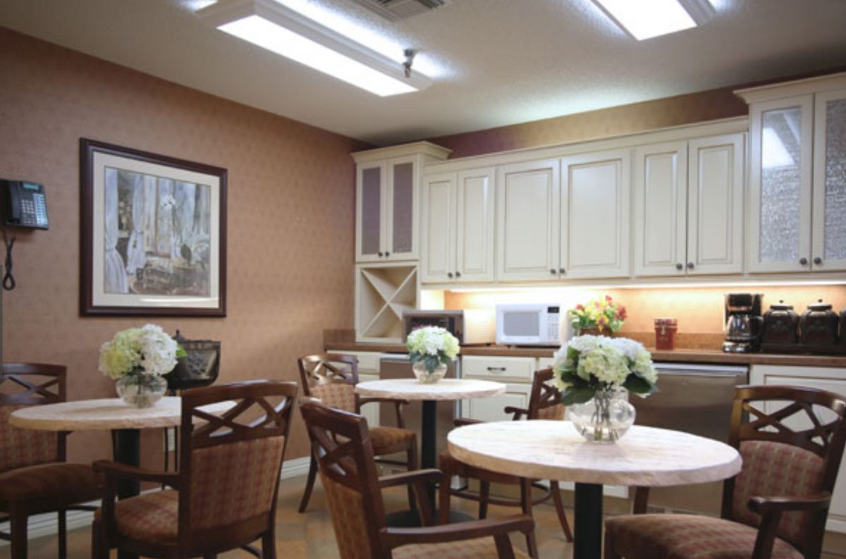 A cozy kitchen dining area with wooden furniture and floral decorations.