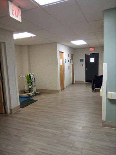 A hallway with doors leading to different rooms, featuring some decorative plants and suitable lighting.