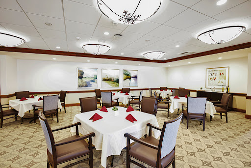 A beautifully arranged dining room with elegantly set tables and tasteful artwork on the walls.