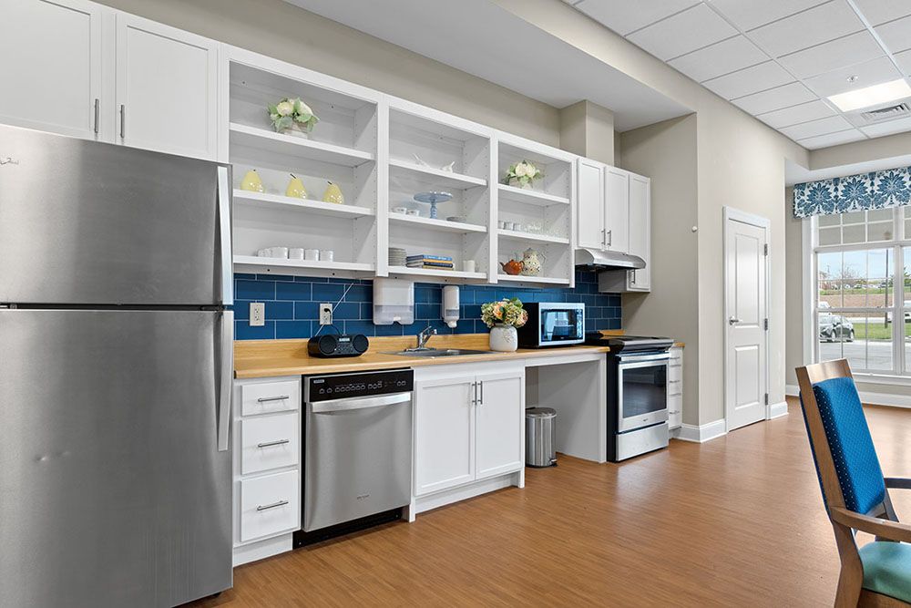 A modern kitchen with white cabinets, a blue backsplash, and stainless steel appliances.