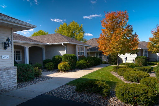 A picturesque neighborhood showcasing charming houses surrounded by vibrant autumn foliage and a clear blue sky.