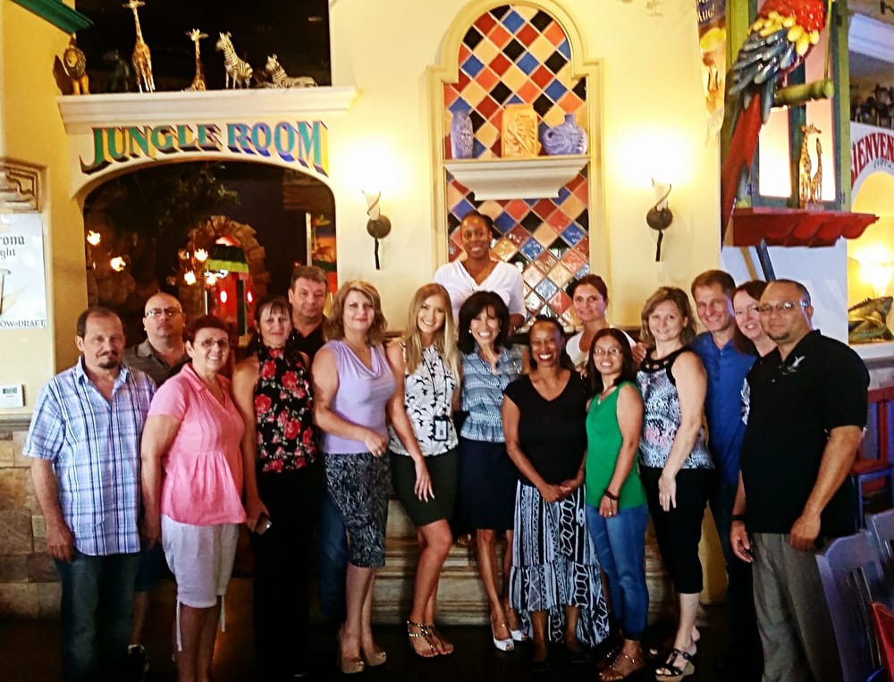 A group of people posing for a photo inside a restaurant with colorful decor.