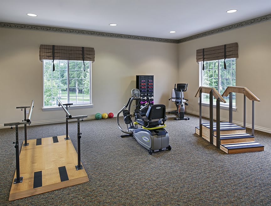 A well-lit rehabilitation gym with various exercise equipment.