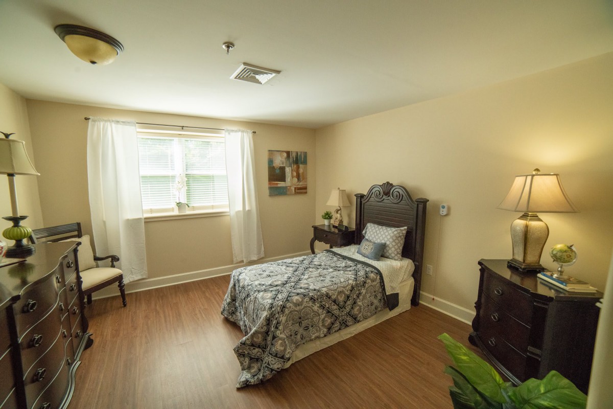 Cozy bedroom with a single bed, window, and decorative elements.