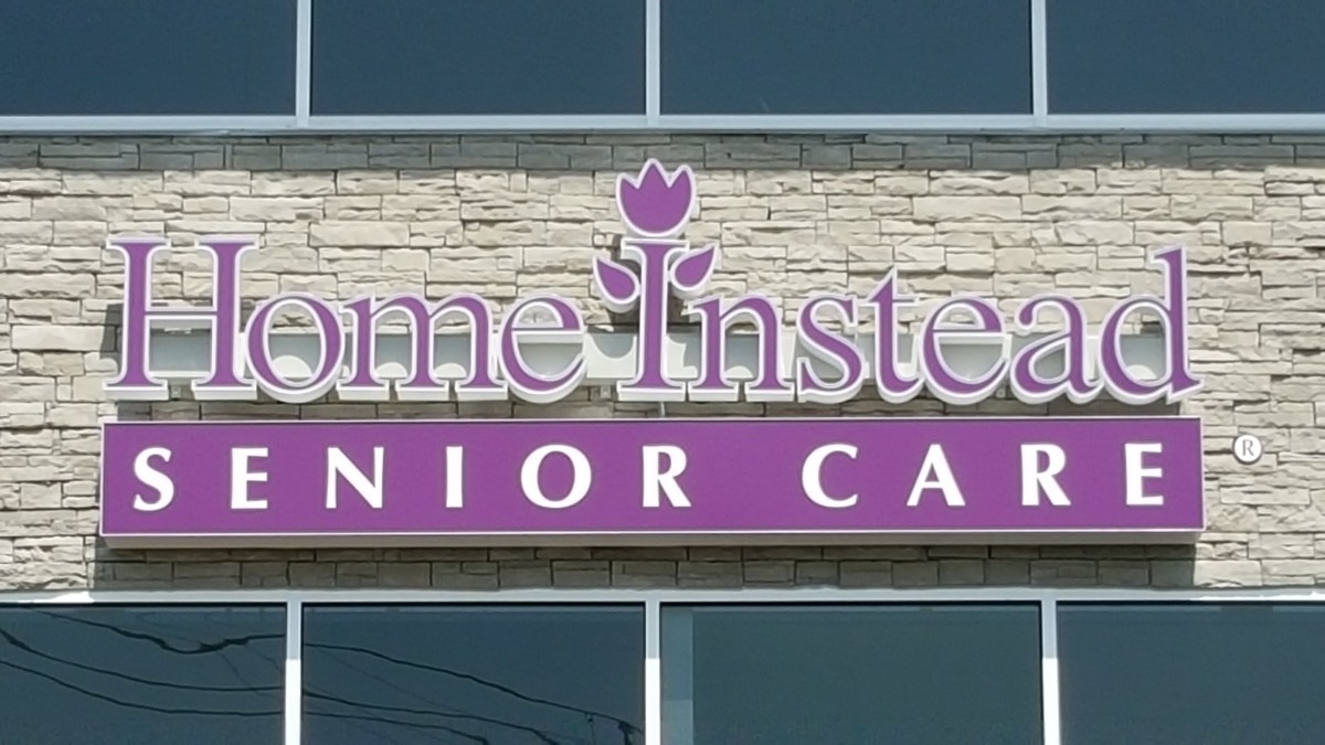 A sign for a senior care facility on the exterior of a building.