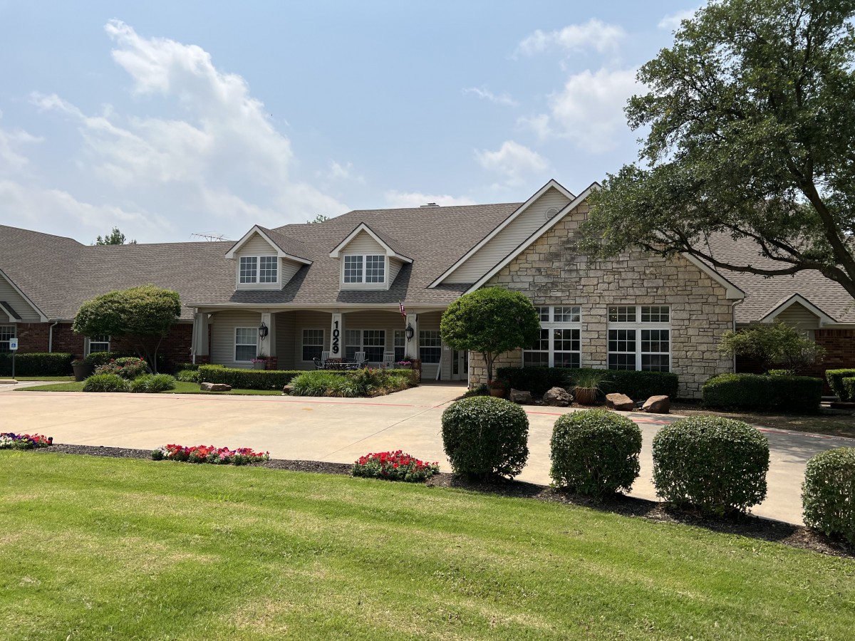 A large suburban house with a well-maintained front yard and a spacious driveway.