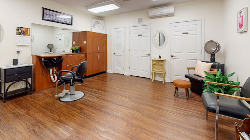 A well-organized salon area featuring stylish chairs, mirrors, and wooden flooring.