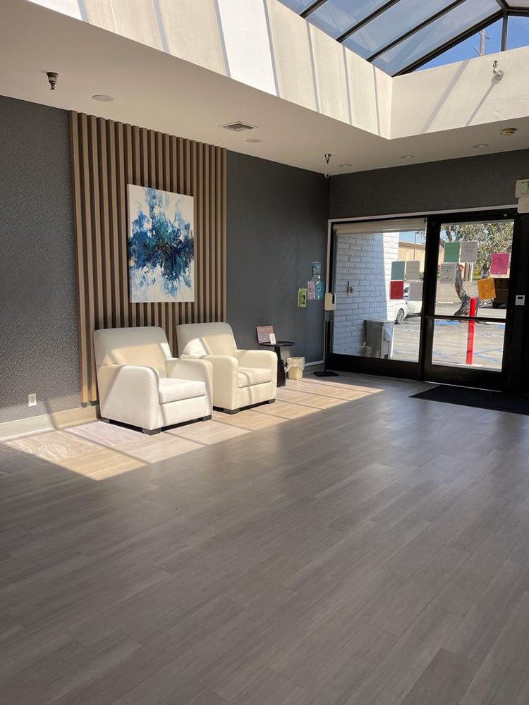 A modern lobby with comfortable seating and contemporary artwork, illuminated by natural light.