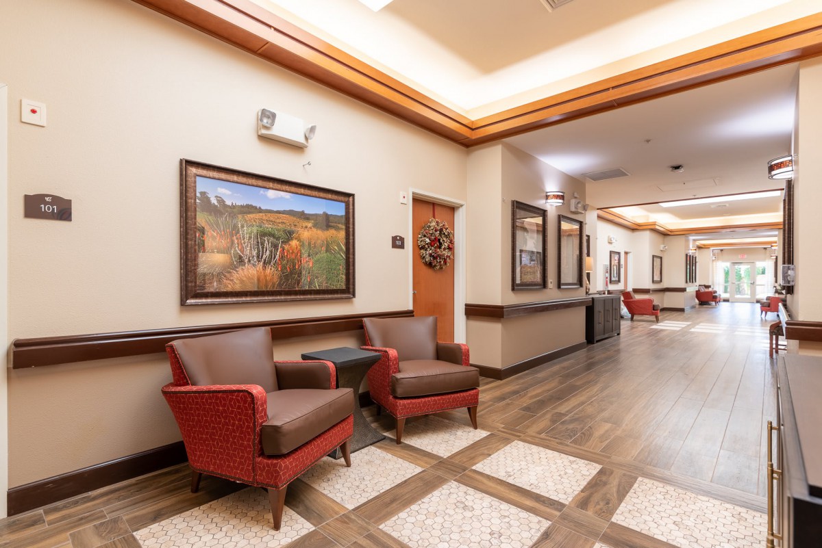 A well-lit hallway with comfortable seating and artwork on the walls.