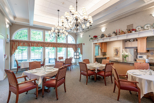 An inviting dining room featuring elegant chandeliers and comfortable seating, bathed in natural light.