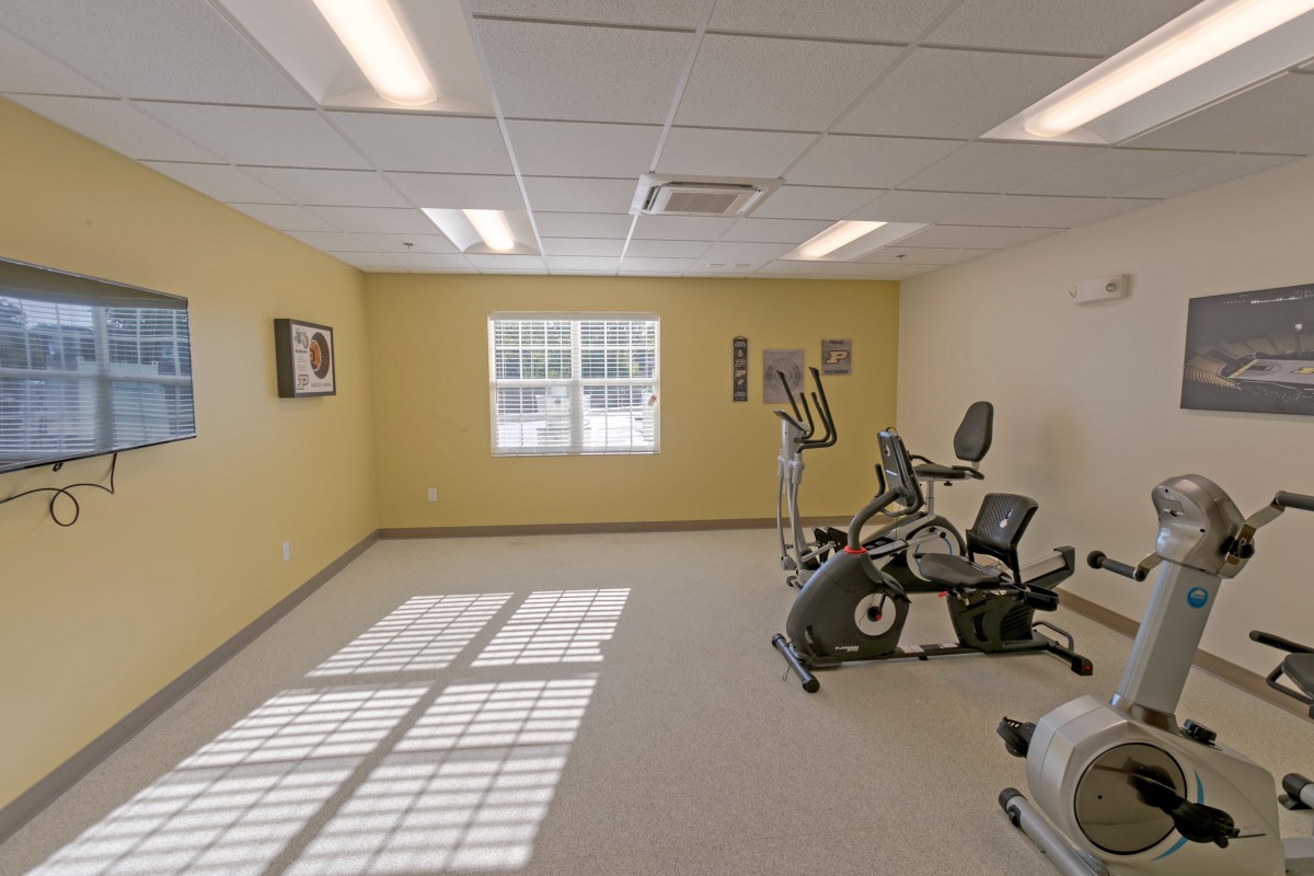 A small gym with fitness equipment including an elliptical and a stationary bike.