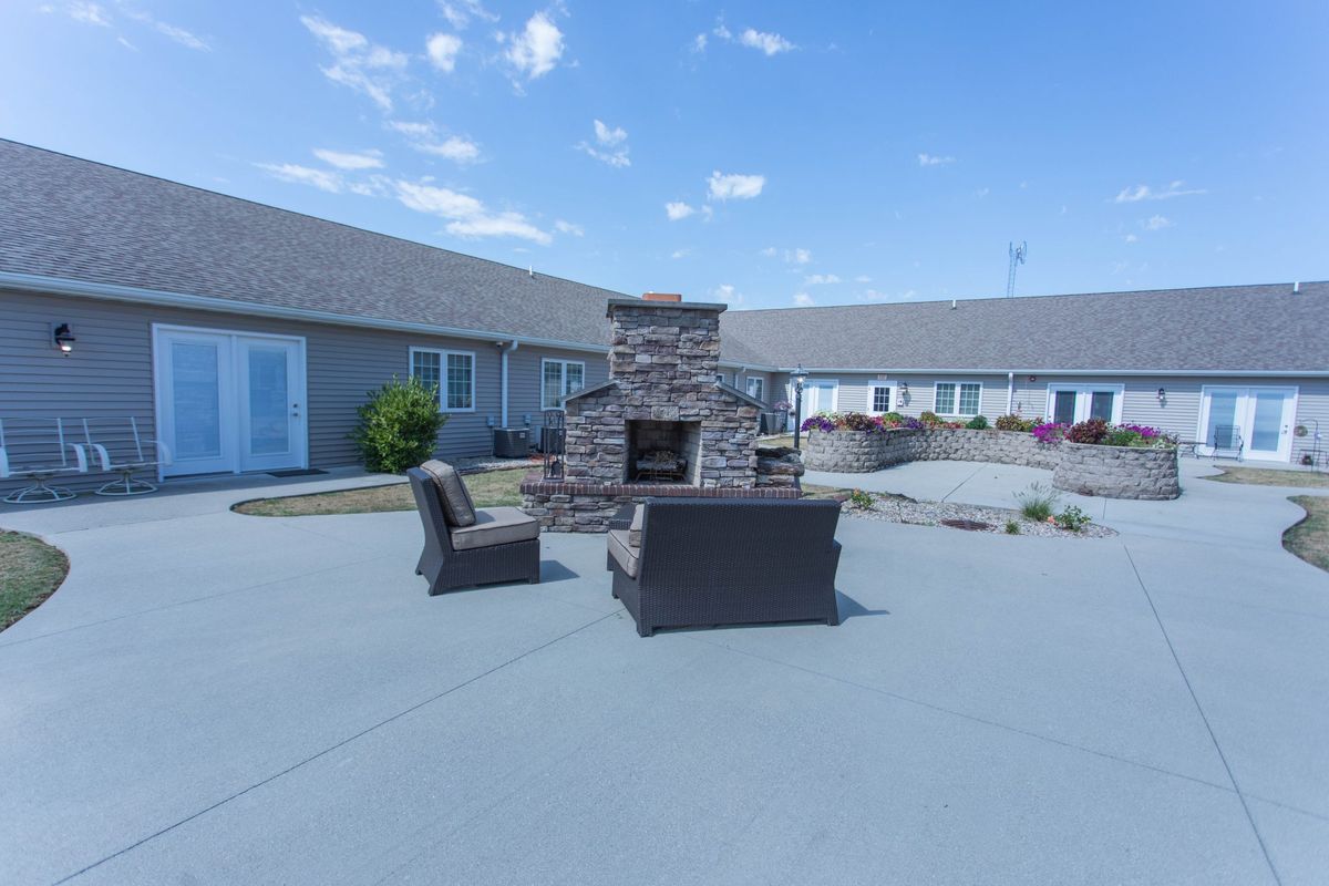 Outdoor patio area with seating and a central fireplace.