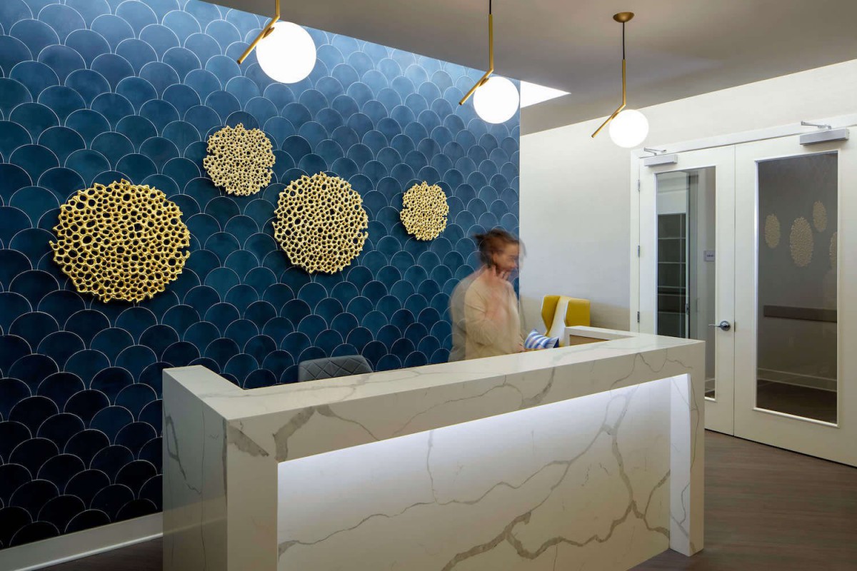 A modern reception area featuring a stylish desk and decorative wall art.