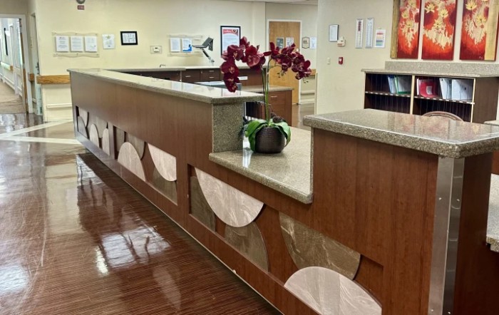 A modern reception desk with decorative elements and a flower arrangement.