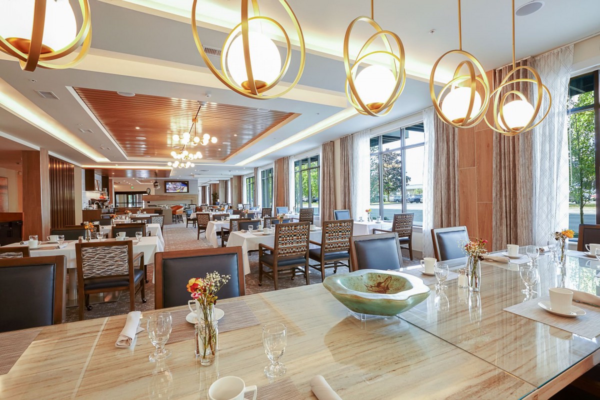 A modern and elegant restaurant interior with warm lighting and stylish chandeliers.