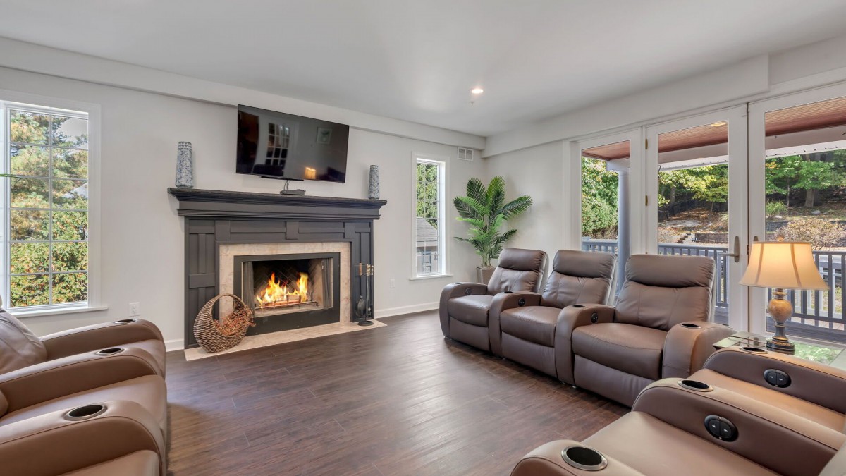 A cozy living room with a fireplace, wall-mounted television, and comfortable recliner chairs.