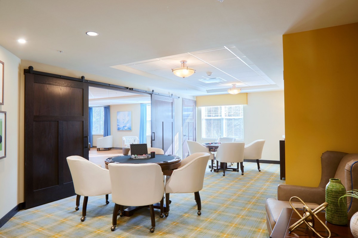 A modern dining area with elegant chairs and tables, featuring neutral colors and contemporary lighting.