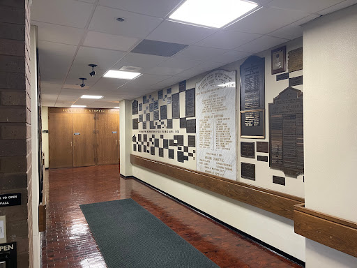 A corridor featuring a wall adorned with various plaques and recognition displays.