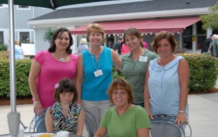 A group of six women posing for a casual indoor photo.