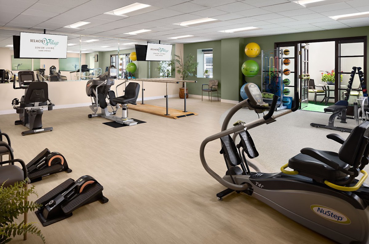 A spacious gym with various exercise equipment, including treadmills and stationary bikes.