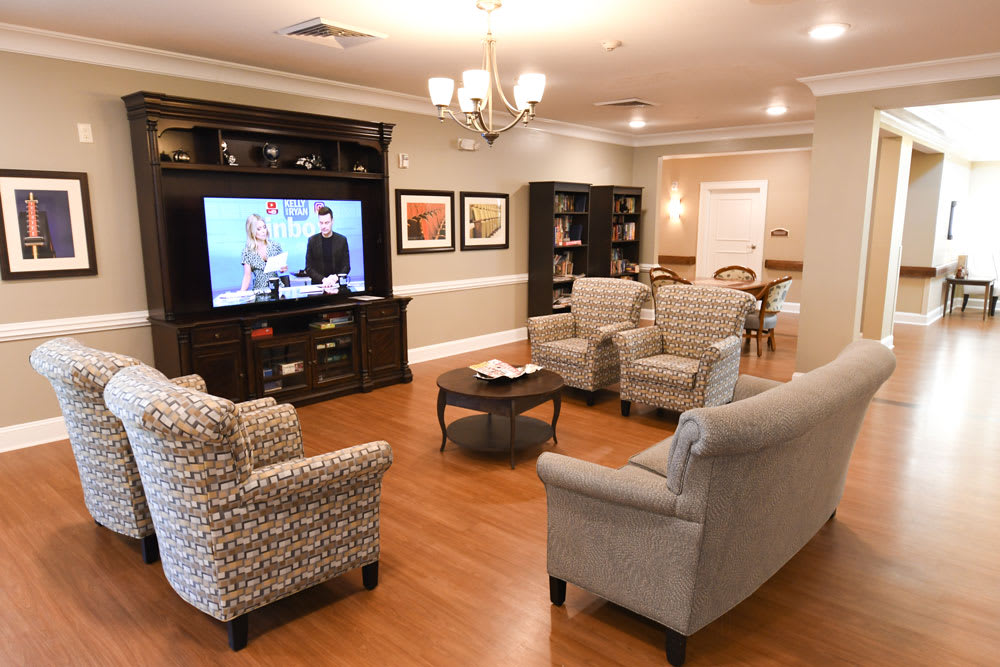 A cozy living room featuring a large television, comfortable seating, and elegant decor.