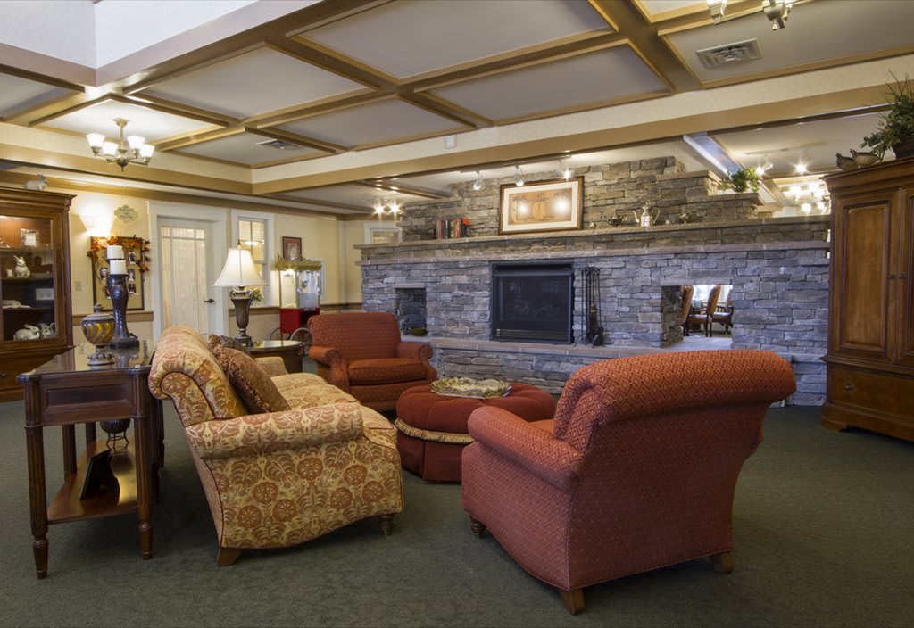 A cozy living room featuring comfortable seating and a large stone fireplace.