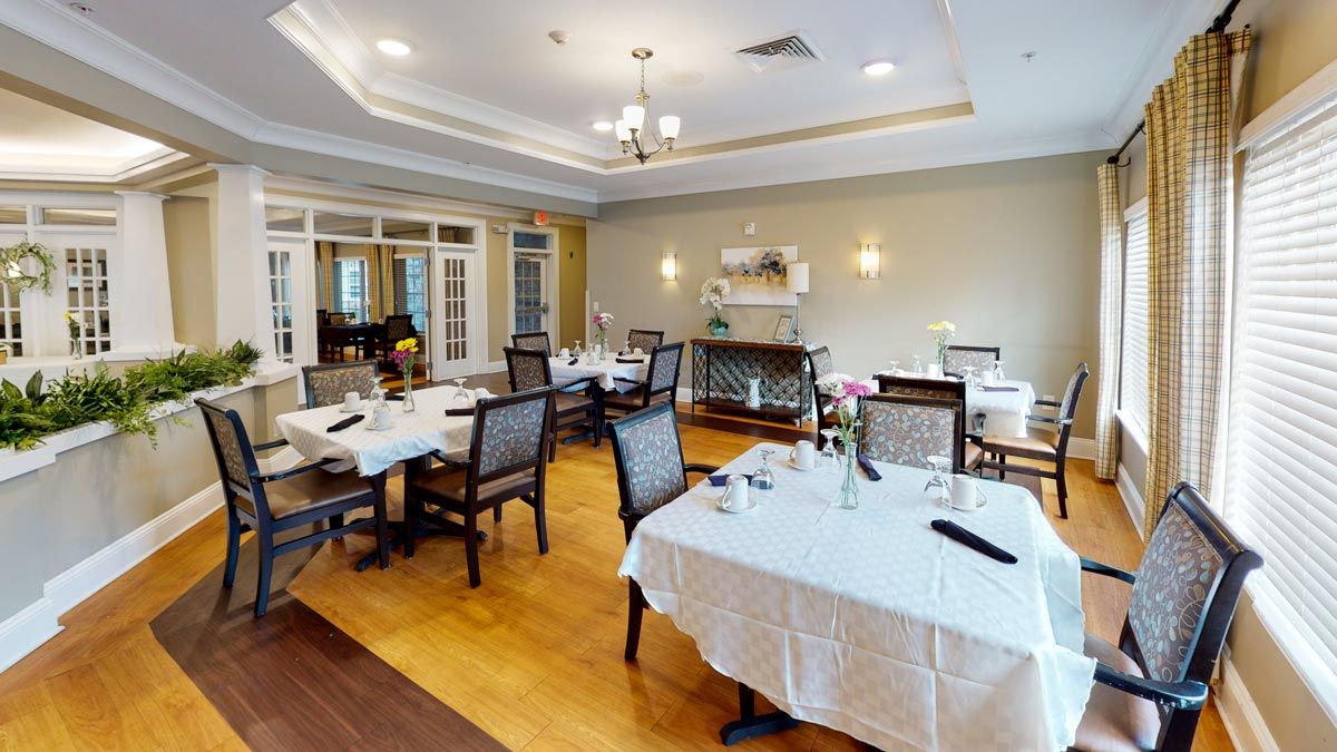 An elegant dining room with neatly arranged tables and chairs, featuring a warm interior design.