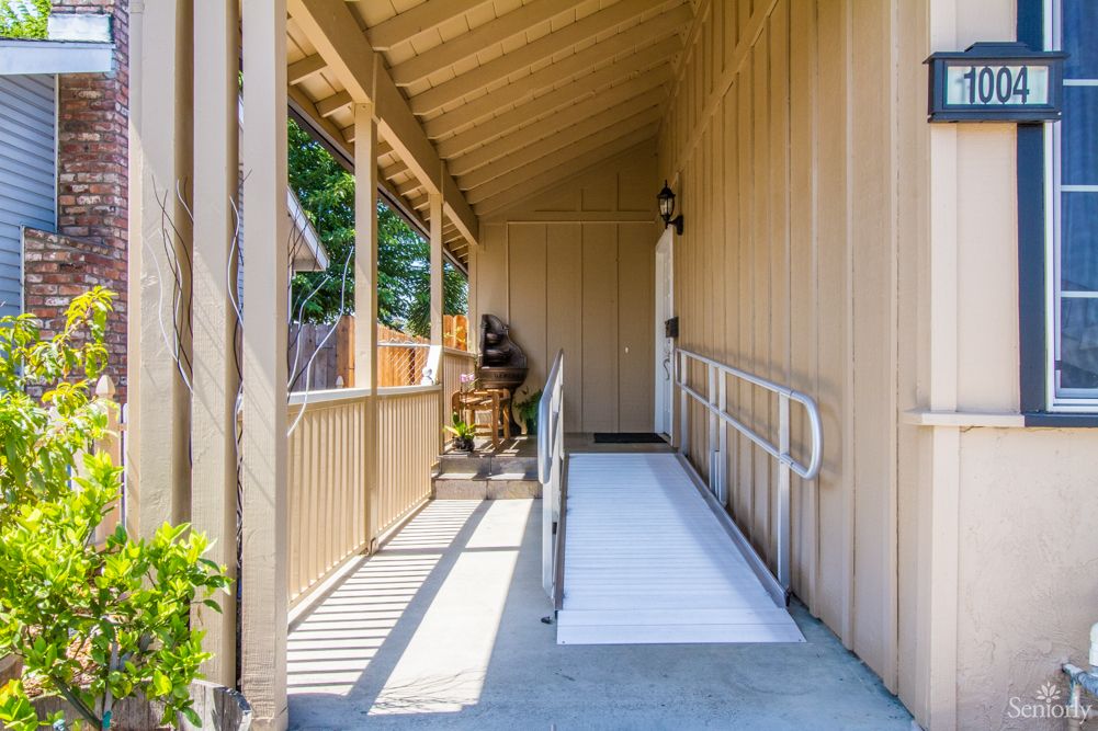 A wooden porch with a wheelchair ramp for accessibility.