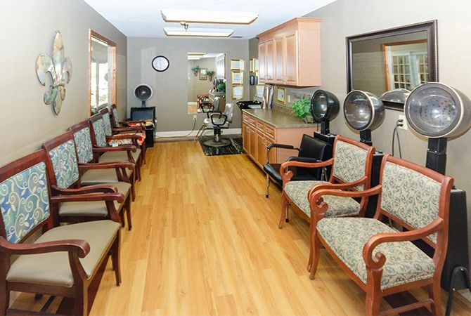 A well-arranged waiting area in a hair salon with comfortable chairs and a wooden floor.