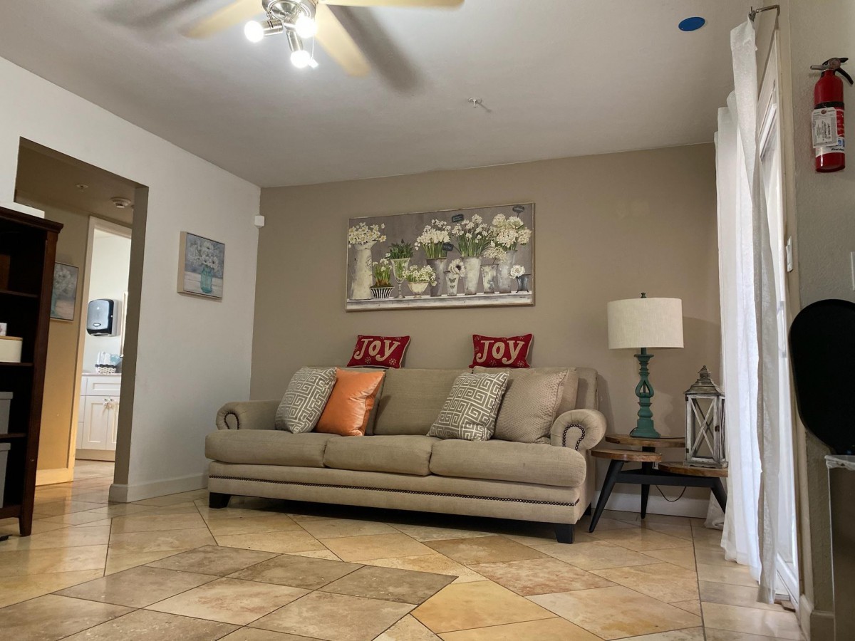 A cozy living room with a beige sofa, decorative cushions, and warm lighting.