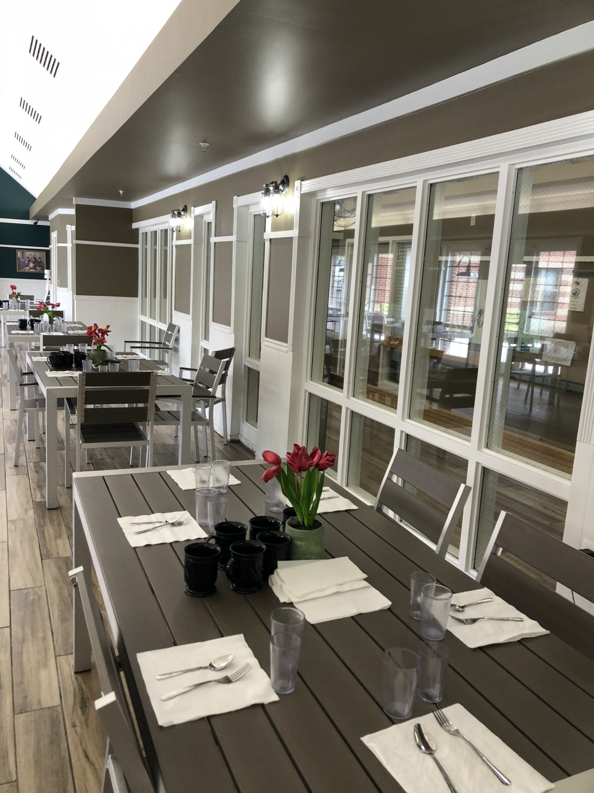 A modern indoor dining area with neatly arranged tables and chairs, adorned with flowers.