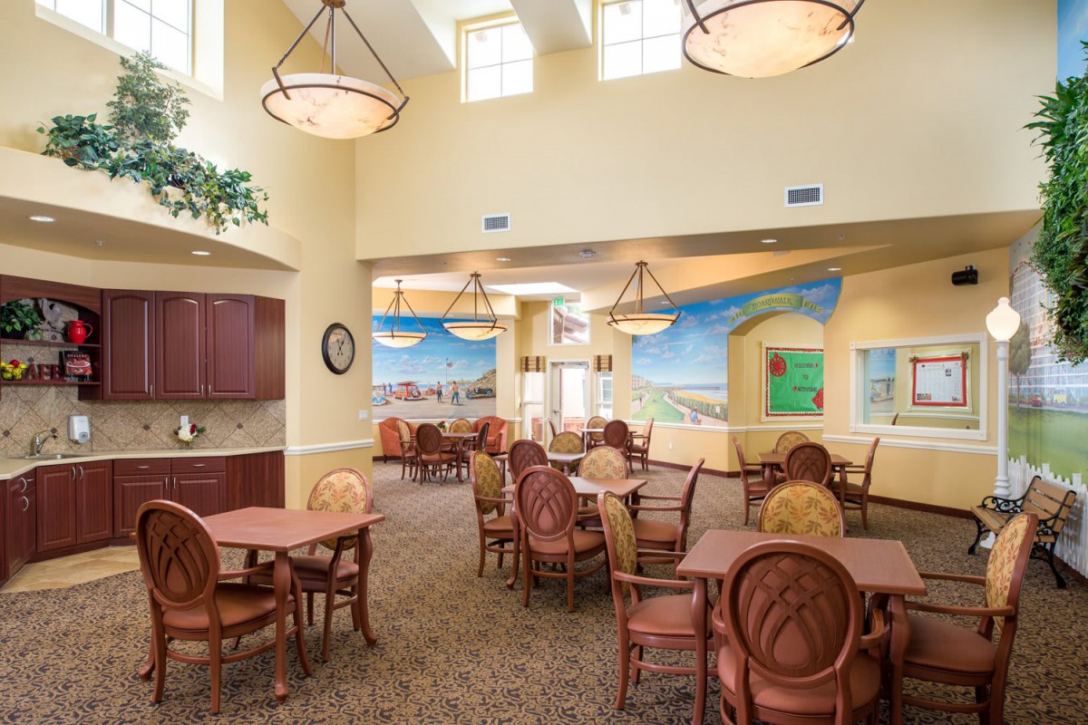 A spacious dining area with neatly arranged tables and chairs, featuring decorative murals and modern lighting.