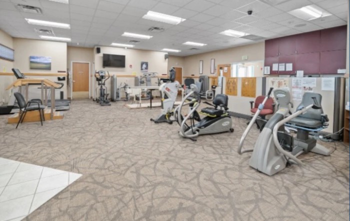A spacious gym with various exercise equipment and machines.