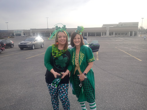 Two friends celebrating St. Patrick's Day in festive green outfits.
