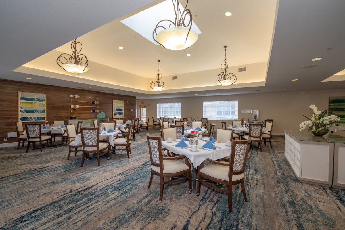 An elegant dining room with beautifully set tables, chandeliers, and tasteful interior decor.