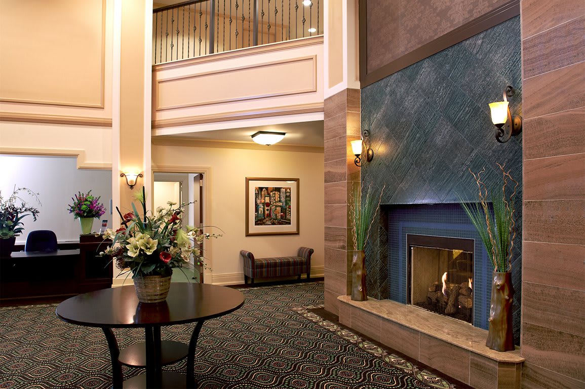 A cozy hotel lobby featuring a fireplace and elegant interior decor.