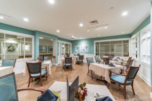A well-arranged dining area with several tables and chairs, featuring elegant decor and soft lighting.