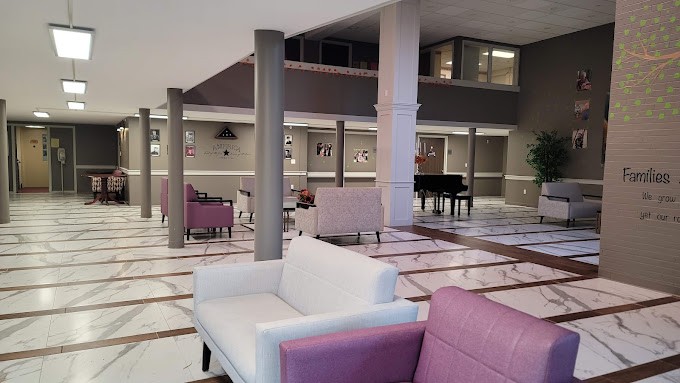 A spacious lobby with modern furnishings and a grand piano.