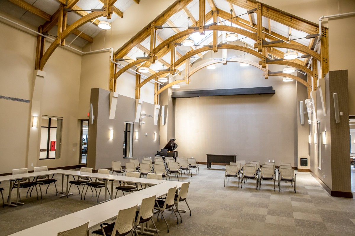 A modern conference room with wooden beams and flexible seating arrangements.