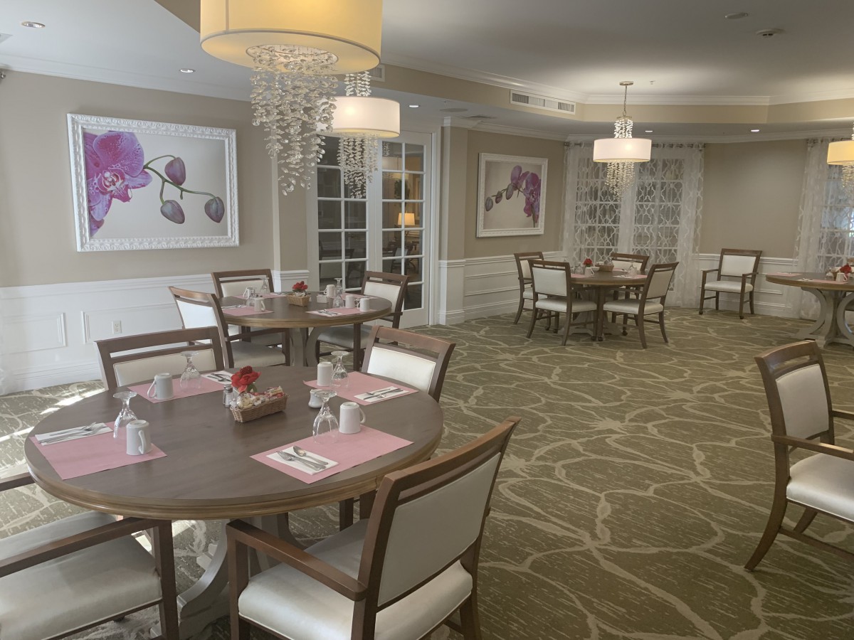 A stylish dining room with elegantly set tables and modern chandeliers.
